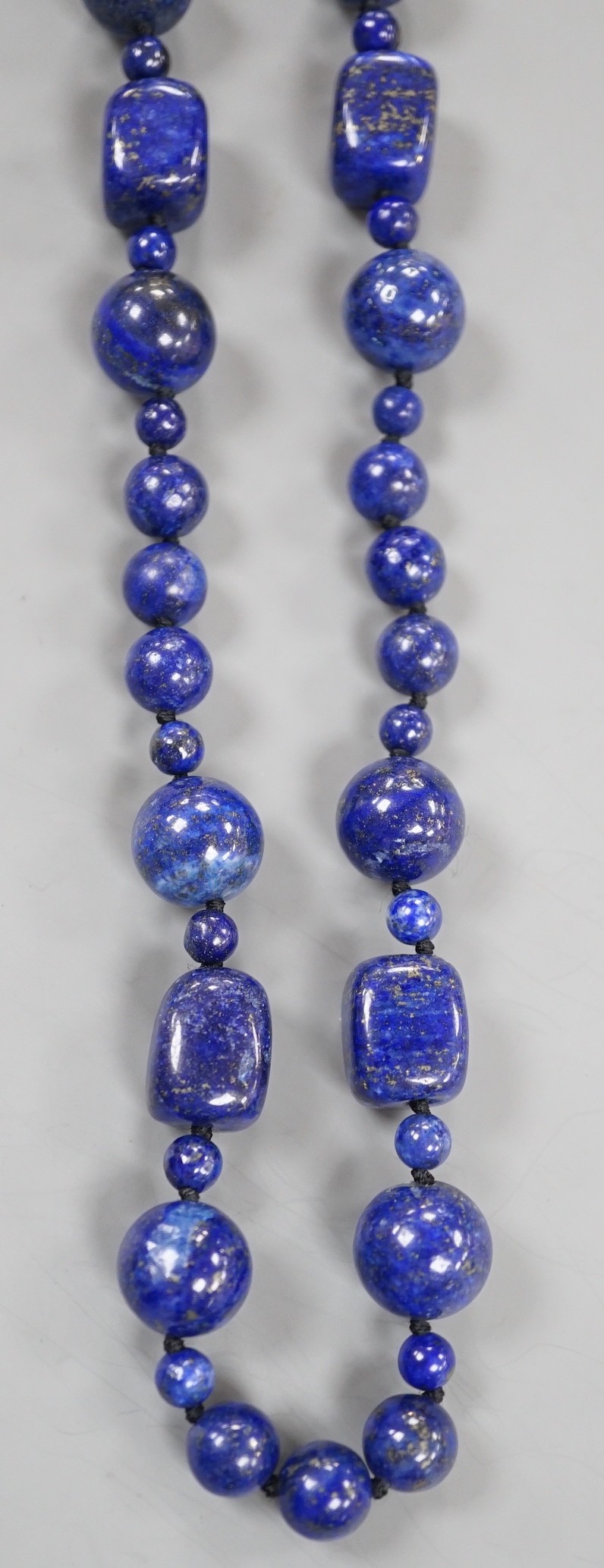 A single strand lapis lazuli round and barrel bead necklace, 72cm.